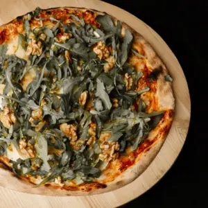 Pizza au fromage de chèvre, noix, miel et ruccola