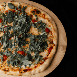 Pizza Primavera avec tomates fraîches, ruccola et fromage râpé