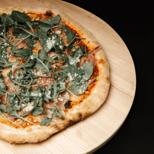 Pizza Ruccola avec jambon cru, fromage râpé et ruccola